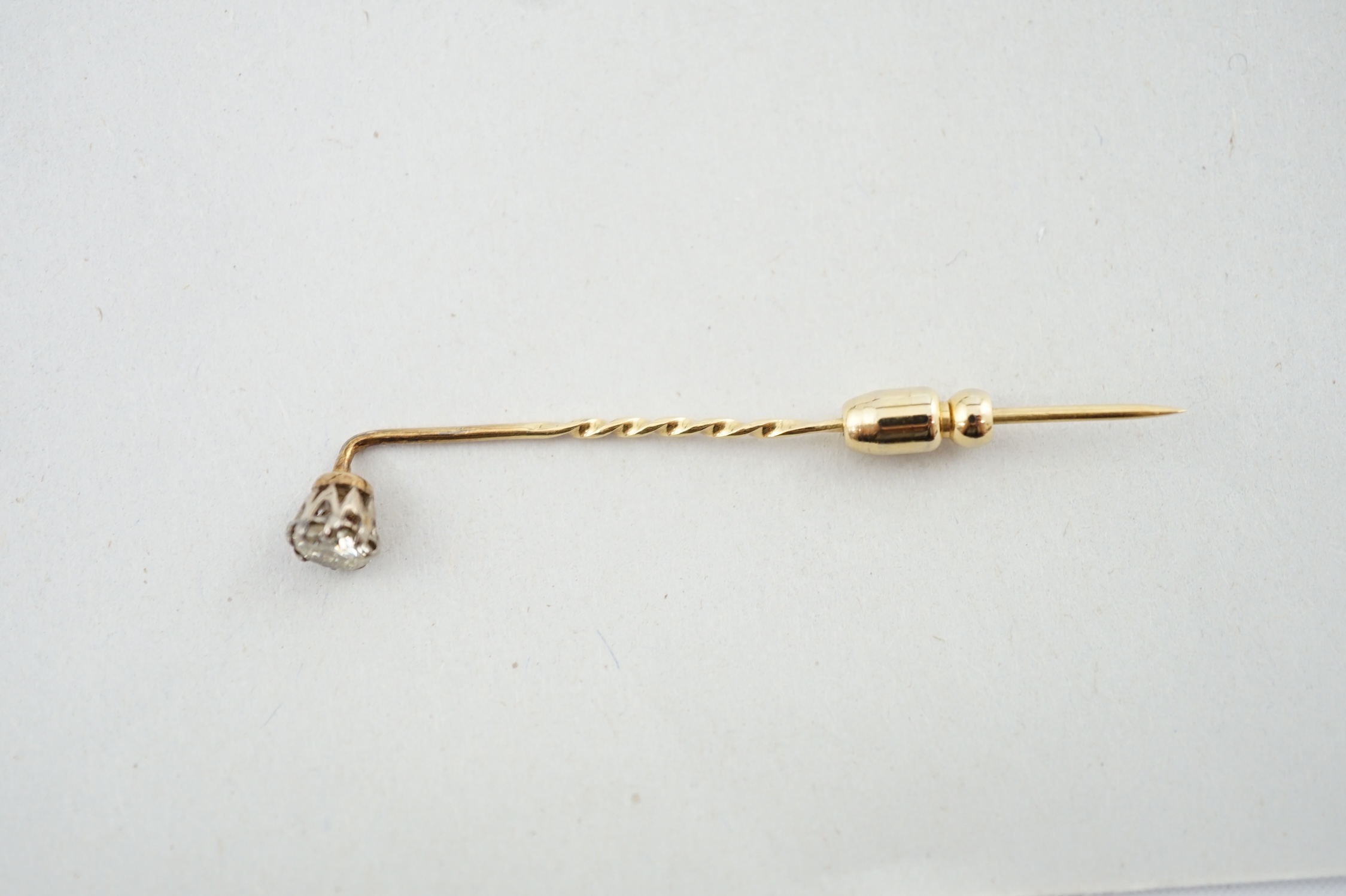 A late Victorian gold and solitaire diamond set stick pin